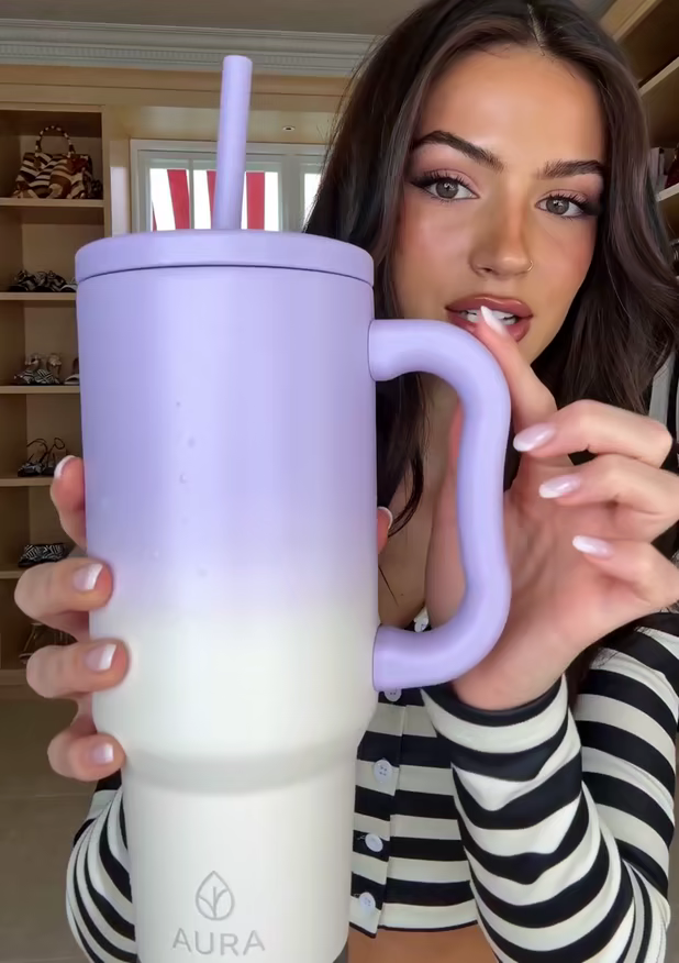 A lilac tumbler held up close to the camera