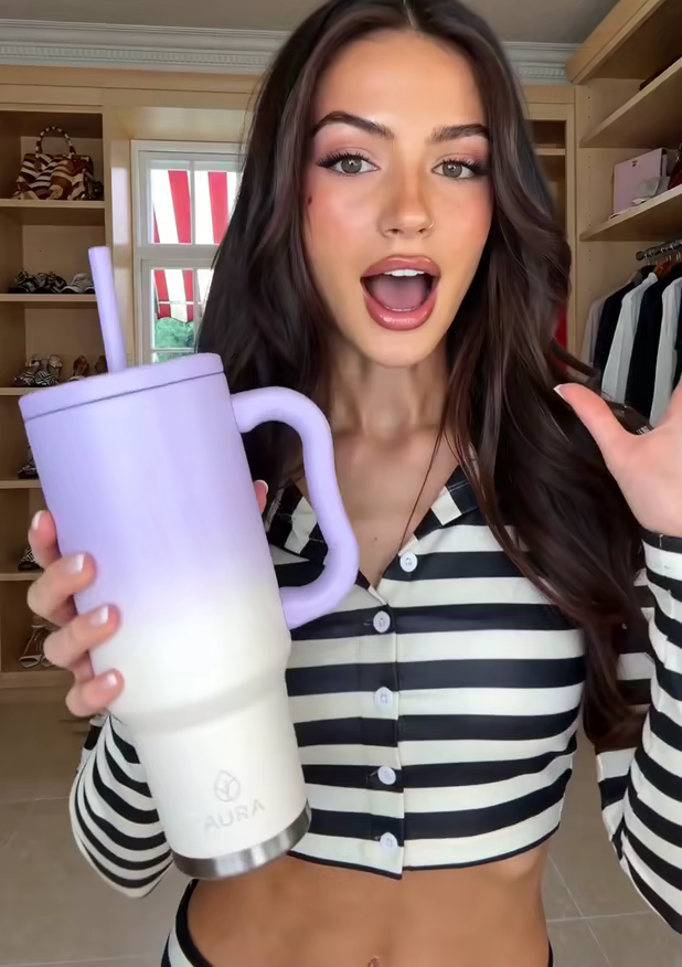 A creator excitedly showing a lilac tumbler with a straw